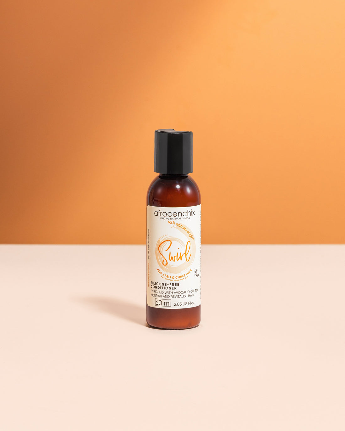 A bottle of Mini Swirl - Silicone-free Conditioner (60ml) by Afrocenchix, positioned against an orange background.